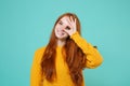 Smiling young redhead woman girl in yellow sweater posing isolated on blue turquoise background. People lifestyle Royalty Free Stock Photo