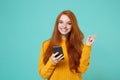 Smiling young redhead woman girl in yellow sweater posing isolated on blue turquoise background in studio. People Royalty Free Stock Photo