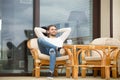 Smiling relaxed man enjoying pleasant morning sitting on terrace Royalty Free Stock Photo