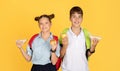 Smiling young schoolchildren with colorful backpacks holding apples and sandwiches Royalty Free Stock Photo