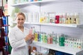 Smiling young seller advising on dog shampoo Royalty Free Stock Photo