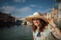 Smiling young solo traveller woman in floral dress