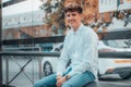 Smiling young Spanish male sitting on a bench waiting for a bus Royalty Free Stock Photo