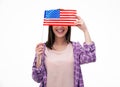 Smiling young student covering her eyes with flag Royalty Free Stock Photo