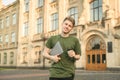 Smiling young student man holding laptop computer looking at camera on a university background. Confident young smiling male Royalty Free Stock Photo