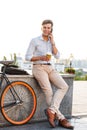 Smiling young stylish man talking on mobile phone Royalty Free Stock Photo