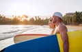 Smiling Young teen boy son with father surfboarders go to the sea for surfing. They have a winter vacation and enjoy a beautiful Royalty Free Stock Photo