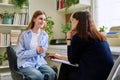 Smiling young teenage female patient talking to professional mental therapist Royalty Free Stock Photo