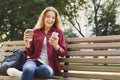 Smiling young texting on smartphone outdoors