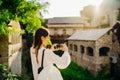 Smiling young tourist taking photos with a smartphone in front of historic landmark old town in Mostar, Bosnia and Herzegovina.