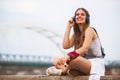 Smiling young urban woman using smart phone outdoors while waiting for her friends Royalty Free Stock Photo