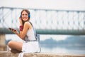 Smiling young urban woman using smart phone outdoors while waiting for her friends Royalty Free Stock Photo