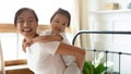 Smiling young vietnamese mother giving piggyback ride to happy baby. Royalty Free Stock Photo