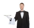 Smiling young waiter holding empty serving tray