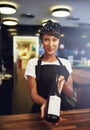 Smiling young waitress presenting a bottle of wine Royalty Free Stock Photo