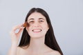 Smiling Young woman applying cosmetics with makeup brush. Happy young woman using cosmetic brush applying face powder looking to Royalty Free Stock Photo