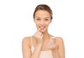 Smiling young woman applying lip balm to her lips Royalty Free Stock Photo