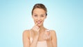 Smiling young woman applying lip balm to her lips Royalty Free Stock Photo