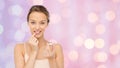 Smiling young woman applying lip balm to her lips Royalty Free Stock Photo