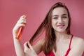 Smiling young woman applying oil mask to hair tips, haircare concept Royalty Free Stock Photo