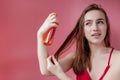 Smiling young woman applying oil mask to hair tips, haircare concept Royalty Free Stock Photo