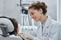 Smiling young woman as friendly female dentist working with child Royalty Free Stock Photo