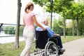 Smiling Young Woman Assisting Her Disabled Father On Wheelchair Royalty Free Stock Photo