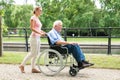 Smiling Young Woman Assisting Her Disabled Father On Wheelchair Royalty Free Stock Photo