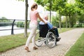 Smiling Young Woman Assisting Her Disabled Father On Wheelchair Royalty Free Stock Photo