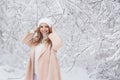 Smiling young woman in a beige jacket in winter forest Royalty Free Stock Photo