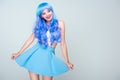 smiling young woman with bright blue hair and skirt