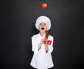 Smiling young woman chef with tomatos juggle Royalty Free Stock Photo