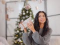 Smiling young woman with christmas present box near christmas tree Royalty Free Stock Photo