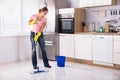 Young Woman Cleaning Kitchen Floor With Mop Royalty Free Stock Photo