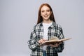 Smiling young woman college student turning pages of book while reading and looking at camera Royalty Free Stock Photo