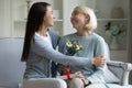 Smiling young woman congratulating happy mature mother with birthday