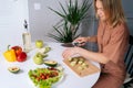 Smiling young woman cutting courgettes for preparing vegetarian salad Royalty Free Stock Photo