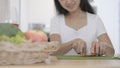 Smiling young woman cutting vegetables on wooden board for making healthy salad. Dieting, healthy lifestyle concept Royalty Free Stock Photo