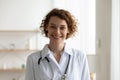 Smiling young woman doctor wearing white medical coat headshot portrait Royalty Free Stock Photo