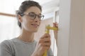 Smiling woman doing a home makeover and measuring with a ruler Royalty Free Stock Photo