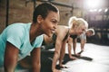 Smiling young woman doing pushups in a gym exercise class