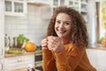 Smiling young woman drinking hot tea in the kitchen Royalty Free Stock Photo