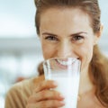 Smiling young woman drinking milk in kitchen Royalty Free Stock Photo