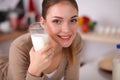 Smiling young woman drinking milk, standing in the Royalty Free Stock Photo