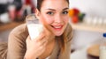 Smiling young woman drinking milk, standing in the kitchen Royalty Free Stock Photo