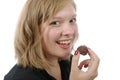 Smiling young woman eating a chocolate candy Royalty Free Stock Photo