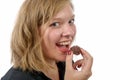 Smiling young woman eating chocolate, on white Royalty Free Stock Photo