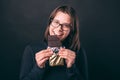 Smiling young woman eating dark chocolate over dark background Royalty Free Stock Photo