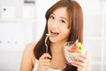 Smiling young woman eating fruits and salad. Royalty Free Stock Photo