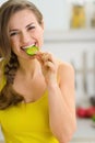 Smiling young woman eating slice of cucumber Royalty Free Stock Photo